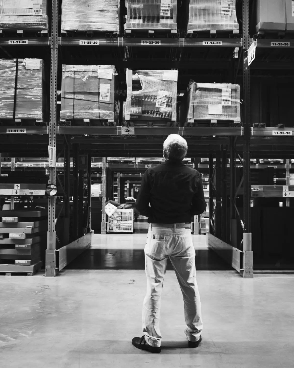 Warehouse worker reviewing stock on tall racks